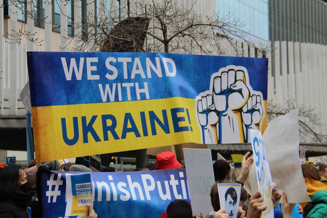 Photo of protestors holding a 'WE STAND WITH UKRAINE' banner