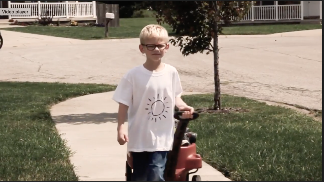 Young boy pulling a wagon down the side walk